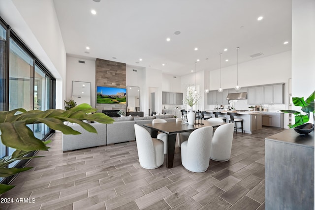 dining space with a large fireplace and a high ceiling