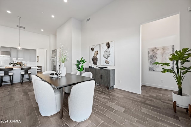 dining area featuring a towering ceiling