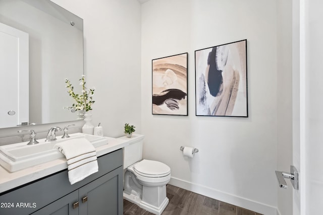 bathroom featuring vanity, wood-type flooring, and toilet