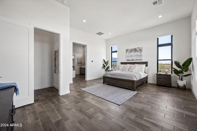 bedroom with dark hardwood / wood-style floors and multiple windows