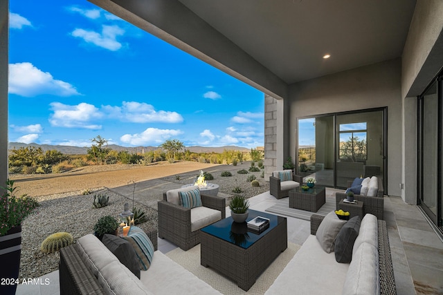 view of patio with a mountain view and an outdoor living space with a fire pit