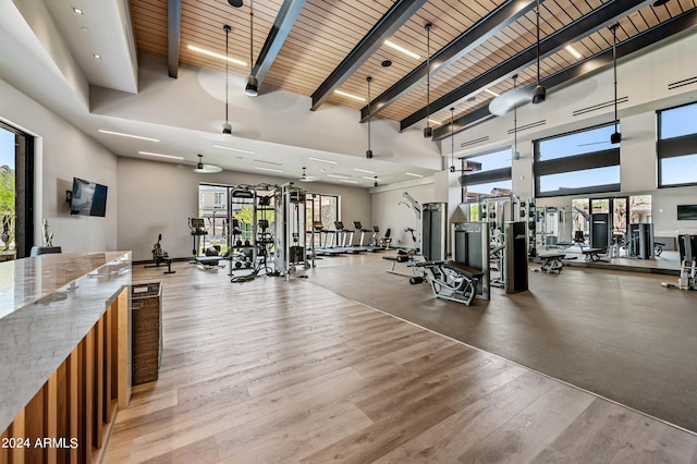 workout area with hardwood / wood-style flooring, wooden ceiling, and a high ceiling