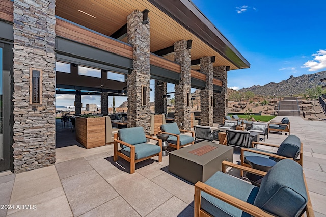 view of patio featuring a mountain view and an outdoor living space with a fire pit