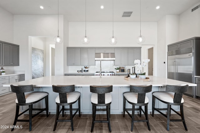 kitchen featuring gray cabinetry, a large island, pendant lighting, and stainless steel built in fridge