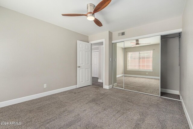 unfurnished bedroom featuring ceiling fan, a closet, and carpet flooring