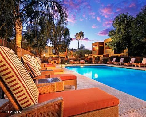 pool at dusk with a patio area