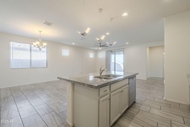 kitchen featuring sink, stainless steel dishwasher, pendant lighting, a kitchen island with sink, and ceiling fan with notable chandelier