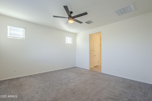 carpeted spare room with ceiling fan and a wealth of natural light