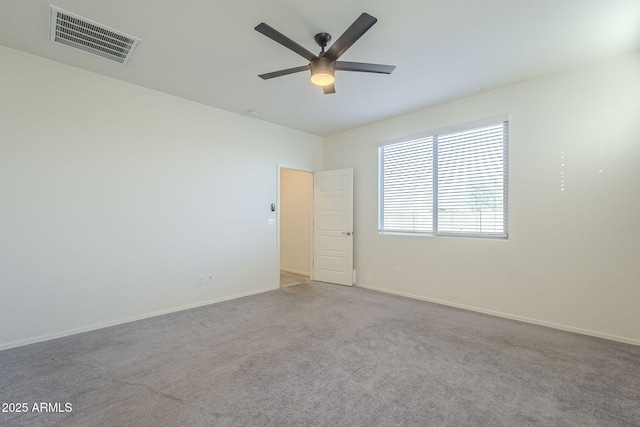 spare room with ceiling fan and light colored carpet