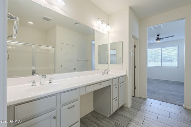 bathroom featuring vanity, ceiling fan, and a shower with shower door