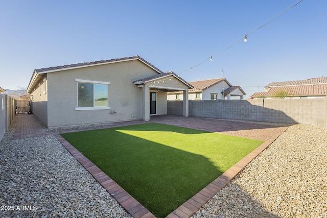 back of house featuring a patio area and a yard