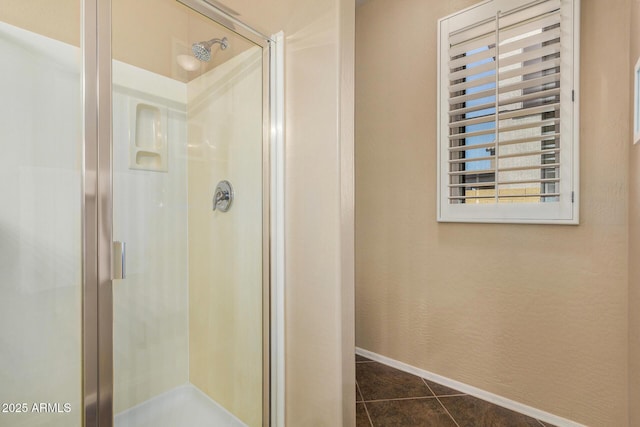 bathroom with walk in shower and tile patterned flooring