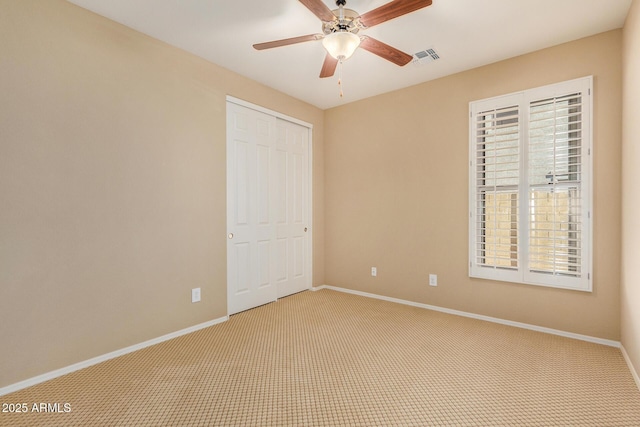 unfurnished bedroom with carpet floors, ceiling fan, and a closet