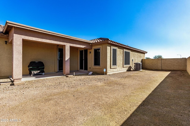 rear view of house with central AC and a patio