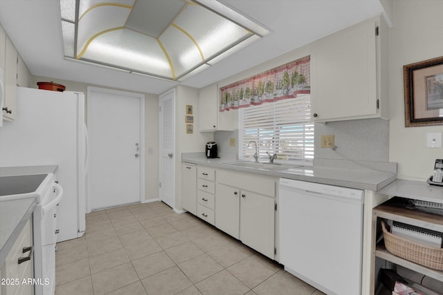 kitchen with white cabinetry, light tile patterned floors, white appliances, and sink