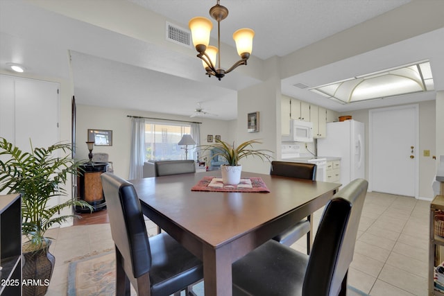 dining area with ceiling fan with notable chandelier and light tile patterned floors