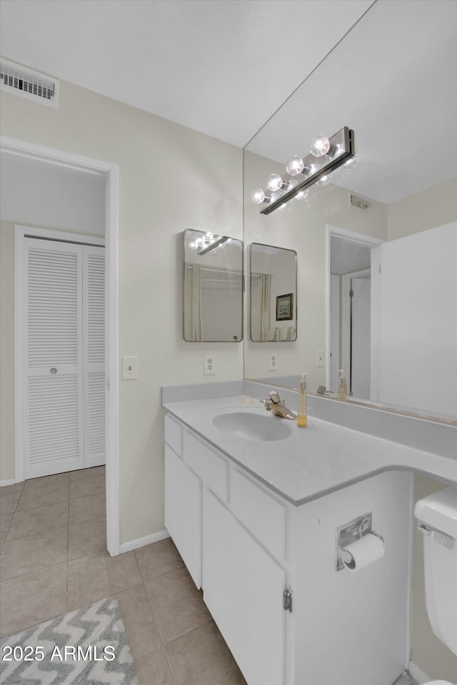 bathroom featuring vanity, toilet, and tile patterned flooring