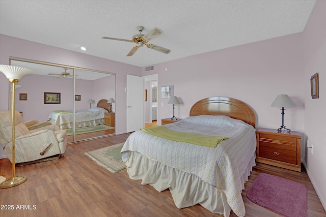 bedroom featuring hardwood / wood-style floors, a textured ceiling, ceiling fan, and a closet