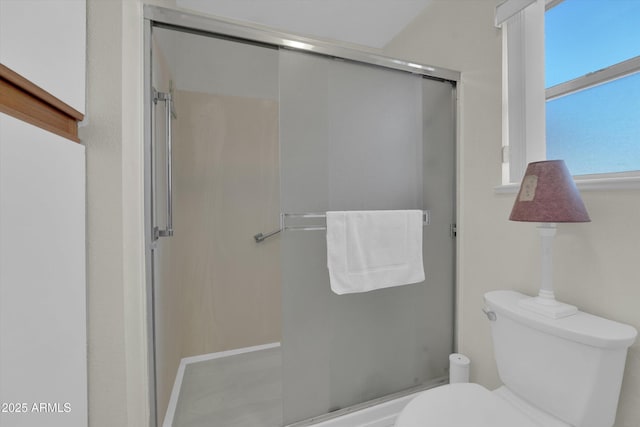 bathroom featuring an enclosed shower and toilet