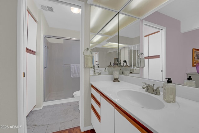 bathroom with vanity, a shower with door, and toilet