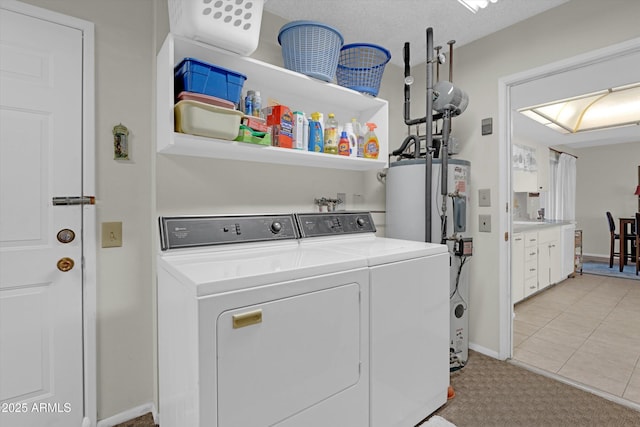 laundry room featuring washing machine and clothes dryer, electric water heater, and water heater