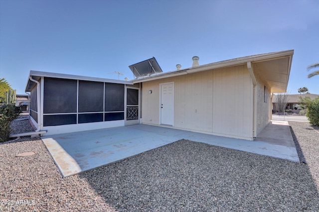 rear view of house with a sunroom and a patio area