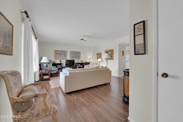 living room featuring ceiling fan, wood-type flooring, and a textured ceiling