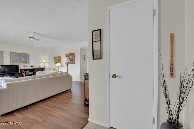 living room with hardwood / wood-style floors, a textured ceiling, and ceiling fan