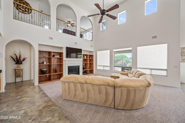 19242 W Pasadena Ave, Litchfield Park, AZ 85340 - living area featuring ceiling fan, a towering ceiling, healthy amount of natural light, and a glass covered fireplace