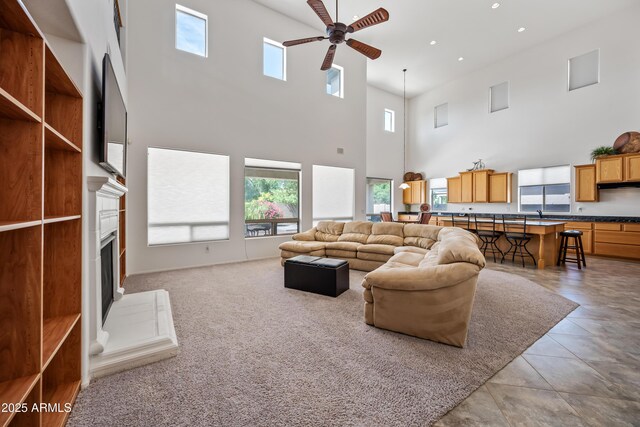 19242 W Pasadena Ave, Litchfield Park, AZ 85340 - living room with a high ceiling, a ceiling fan, recessed lighting, a fireplace with raised hearth, and light tile patterned flooring
