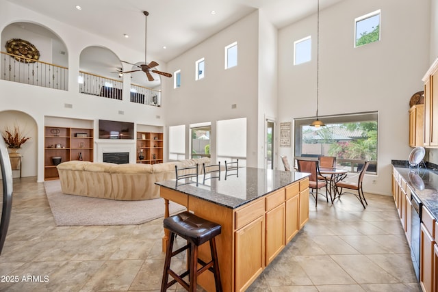 19242 W Pasadena Ave, Litchfield Park, AZ 85340 - kitchen with a towering ceiling, a breakfast bar area, a ceiling fan, dark stone countertops, and recessed lighting