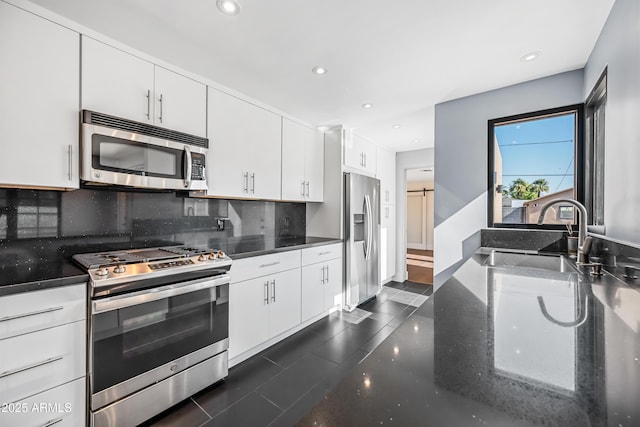 kitchen featuring tasteful backsplash, stainless steel appliances, sink, and white cabinets