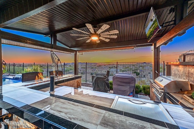 view of patio / terrace with a bar, a fire pit, an outdoor kitchen, area for grilling, and ceiling fan