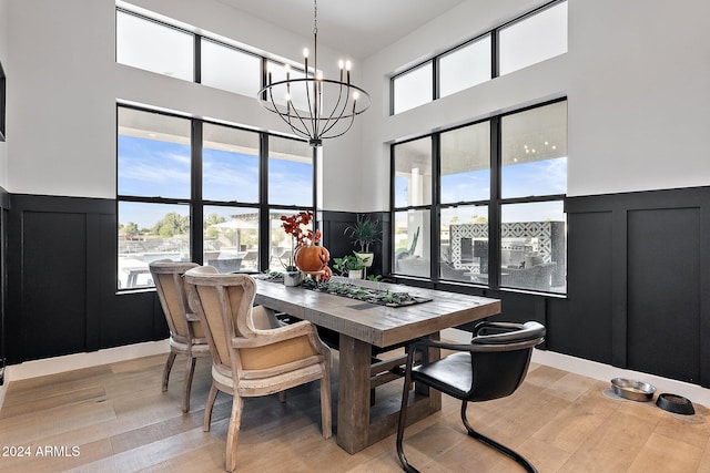 dining space featuring light hardwood / wood-style flooring, a healthy amount of sunlight, and a chandelier