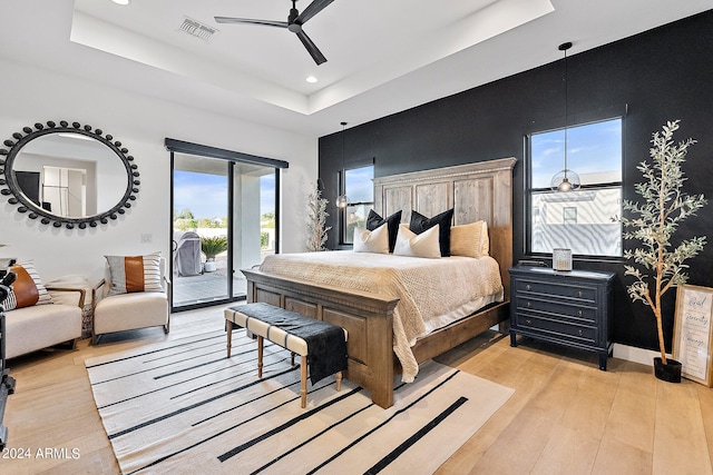 bedroom featuring light hardwood / wood-style floors, multiple windows, access to exterior, and ceiling fan