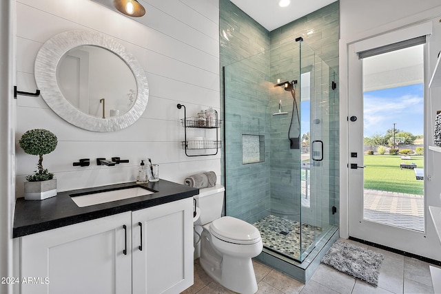 bathroom with vanity, a shower with shower door, toilet, and tile patterned flooring