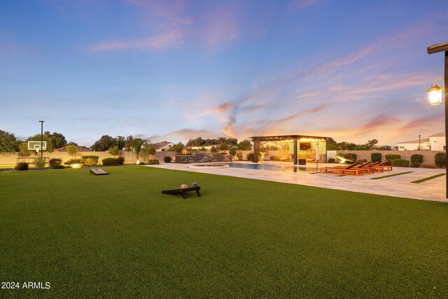 playground at dusk featuring a gazebo, a yard, and a patio area