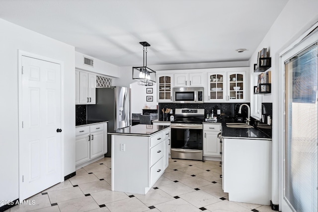 kitchen featuring visible vents, dark countertops, tasteful backsplash, a sink, and appliances with stainless steel finishes