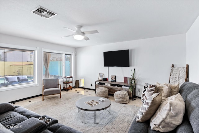 living room with baseboards, light carpet, a ceiling fan, and visible vents