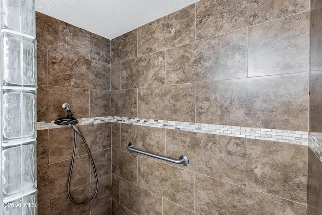 room details with a textured ceiling and tiled shower