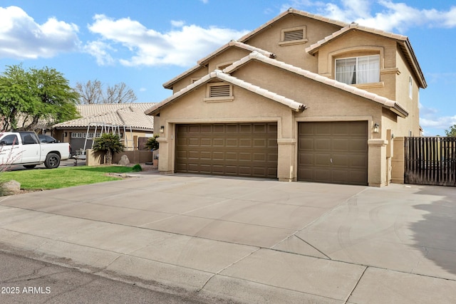 traditional-style home with a tiled roof, fence, driveway, and stucco siding