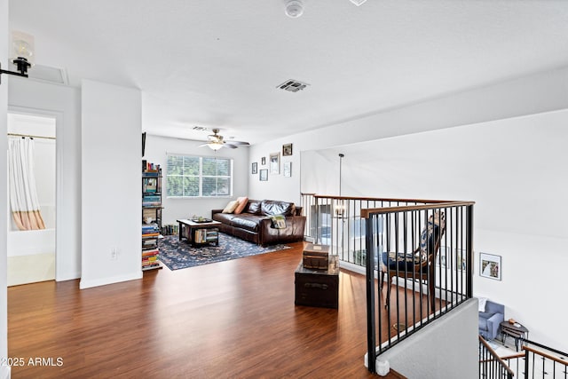 living area featuring ceiling fan, visible vents, and wood finished floors