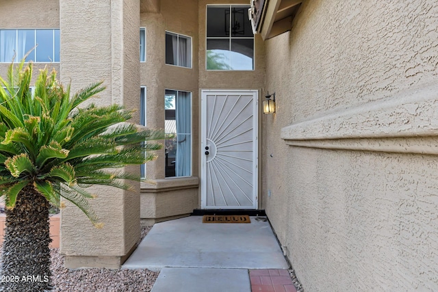 view of exterior entry with stucco siding