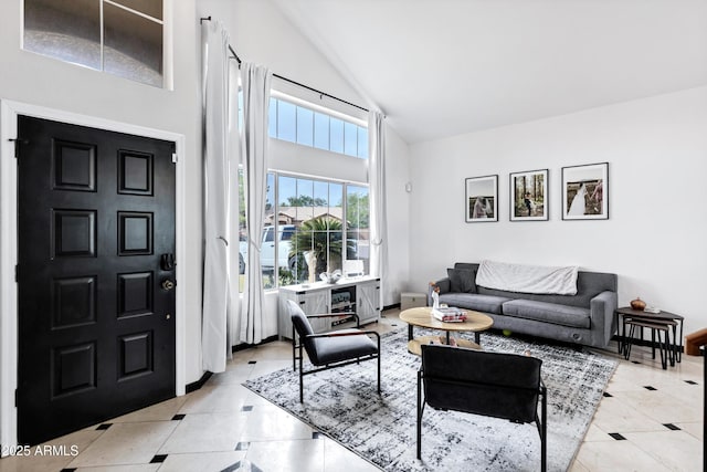 living area featuring high vaulted ceiling and light tile patterned floors