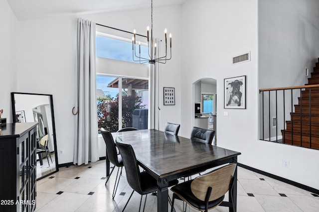 dining area featuring an inviting chandelier, arched walkways, high vaulted ceiling, stairs, and visible vents
