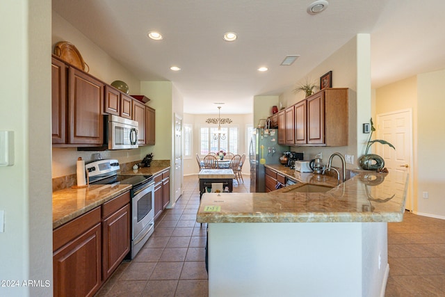 kitchen with tile patterned floors, a notable chandelier, sink, kitchen peninsula, and appliances with stainless steel finishes