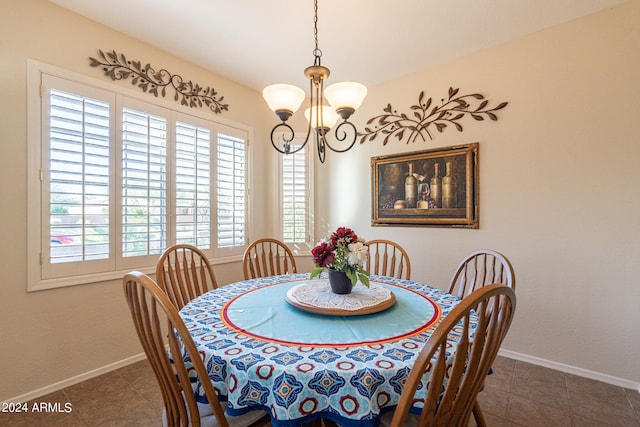 tiled dining room with a chandelier