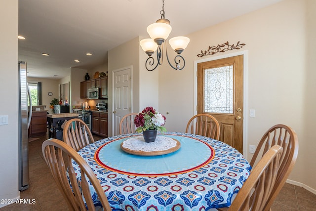 tiled dining room featuring an inviting chandelier