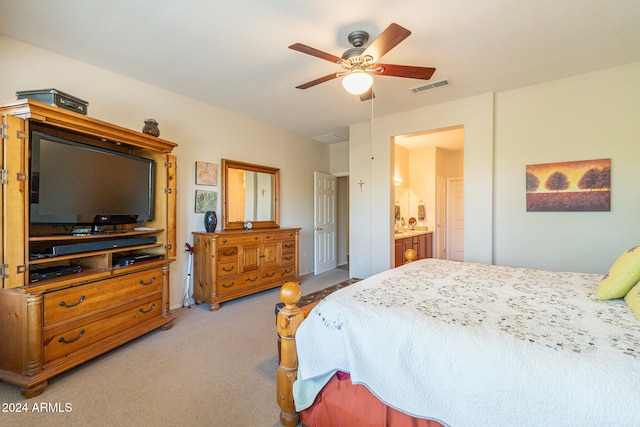 carpeted bedroom with ensuite bathroom and ceiling fan