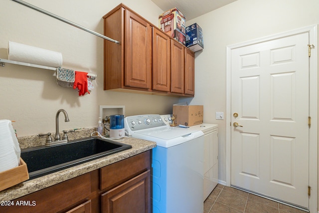 laundry room featuring tile patterned flooring, cabinets, washer and dryer, and sink